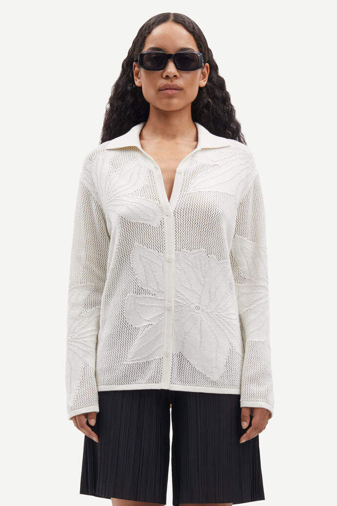 Collared button through knit shirt with floral design within the weave