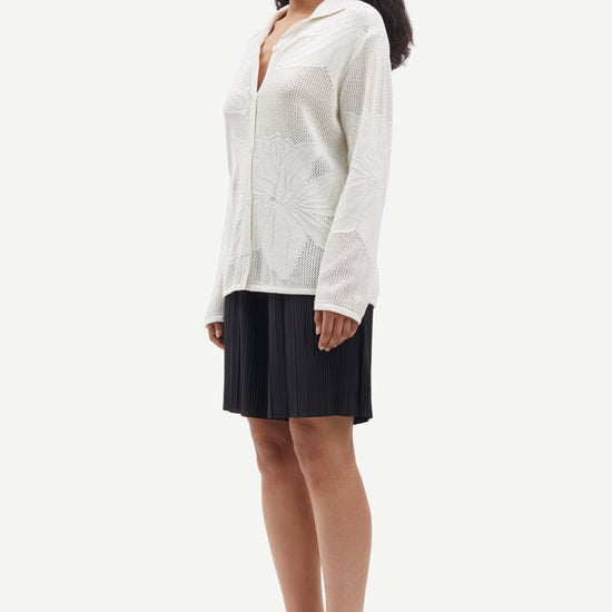 Collared button through knit shirt with floral design within the weave