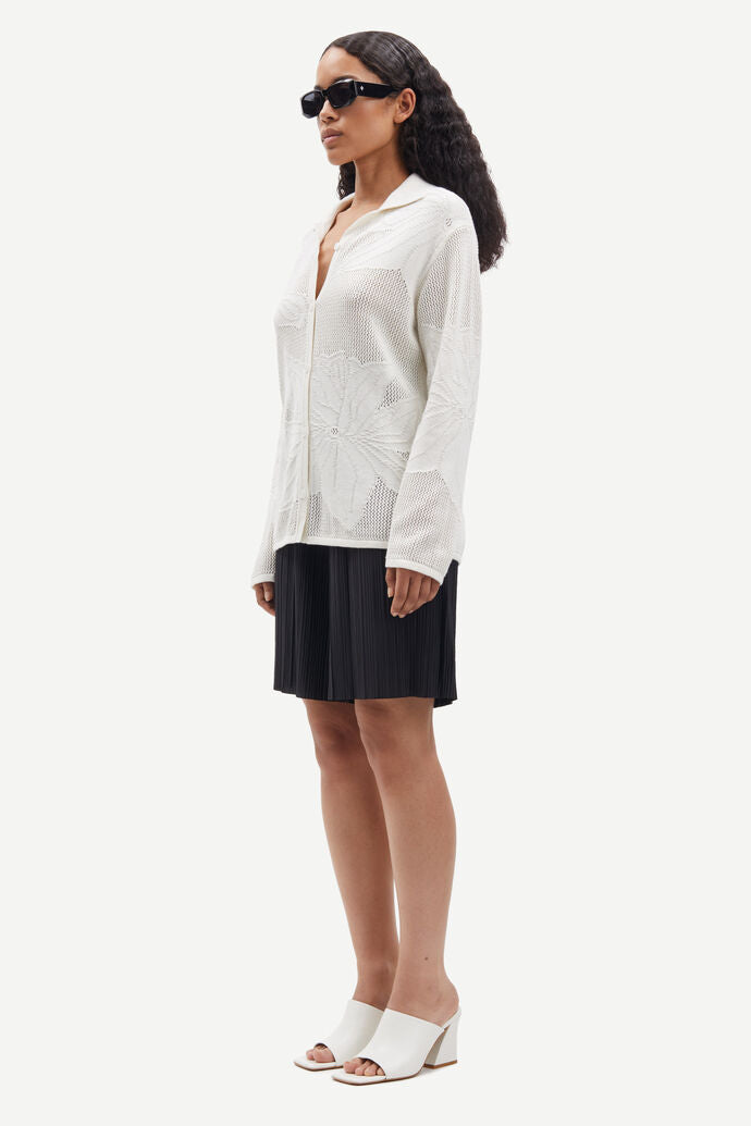 Collared button through knit shirt with floral design within the weave