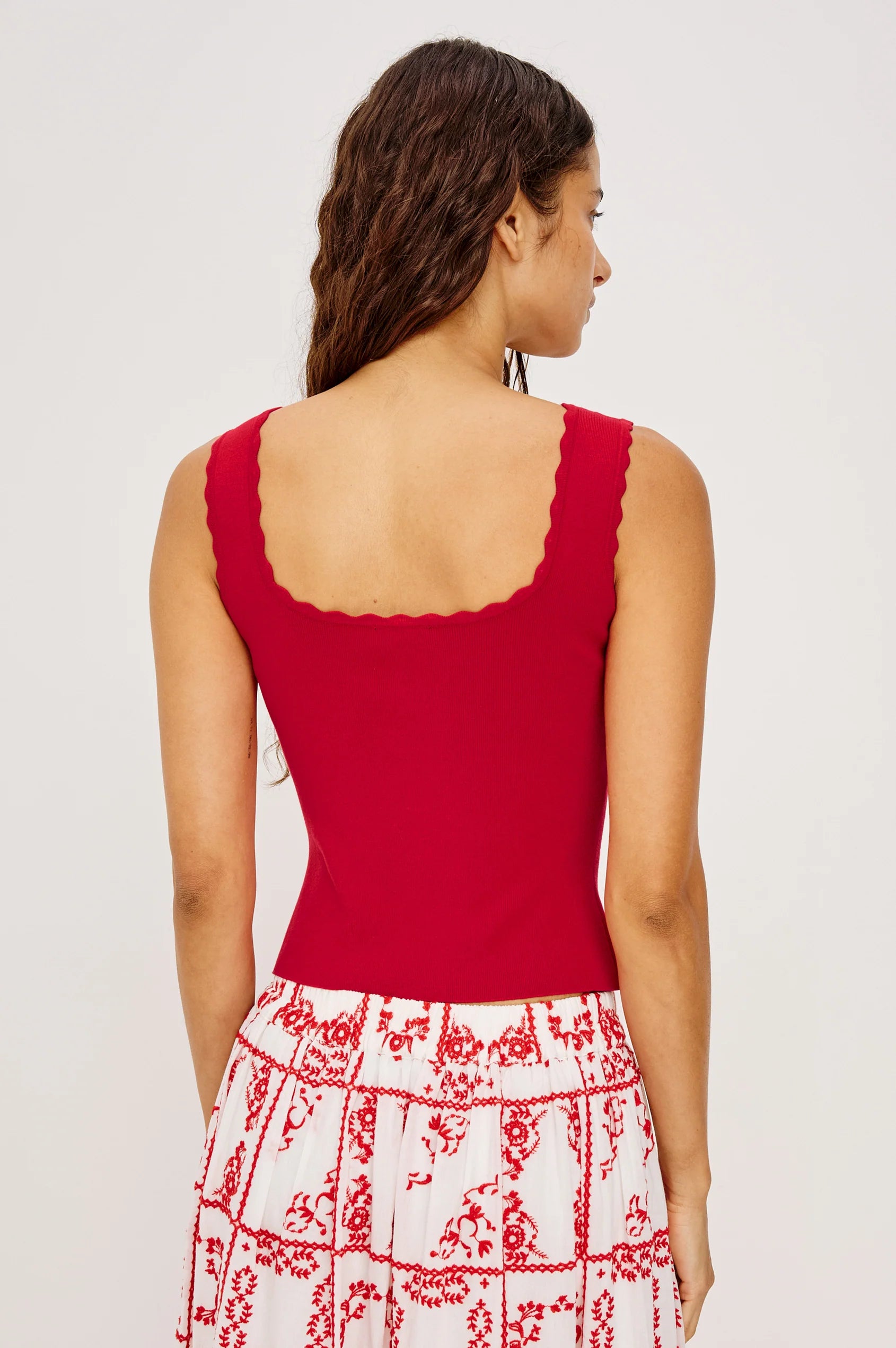Rear view of Woman wearing a red sleeveless top with a white background from Rails