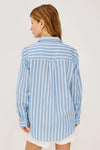 Woman wearing a blue and white Rails shirt striped shirt against a plain background rear view