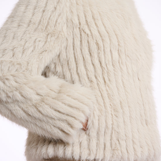 beige faux fur jacket with high neck, central closure and stripe detailing in the fur side view 