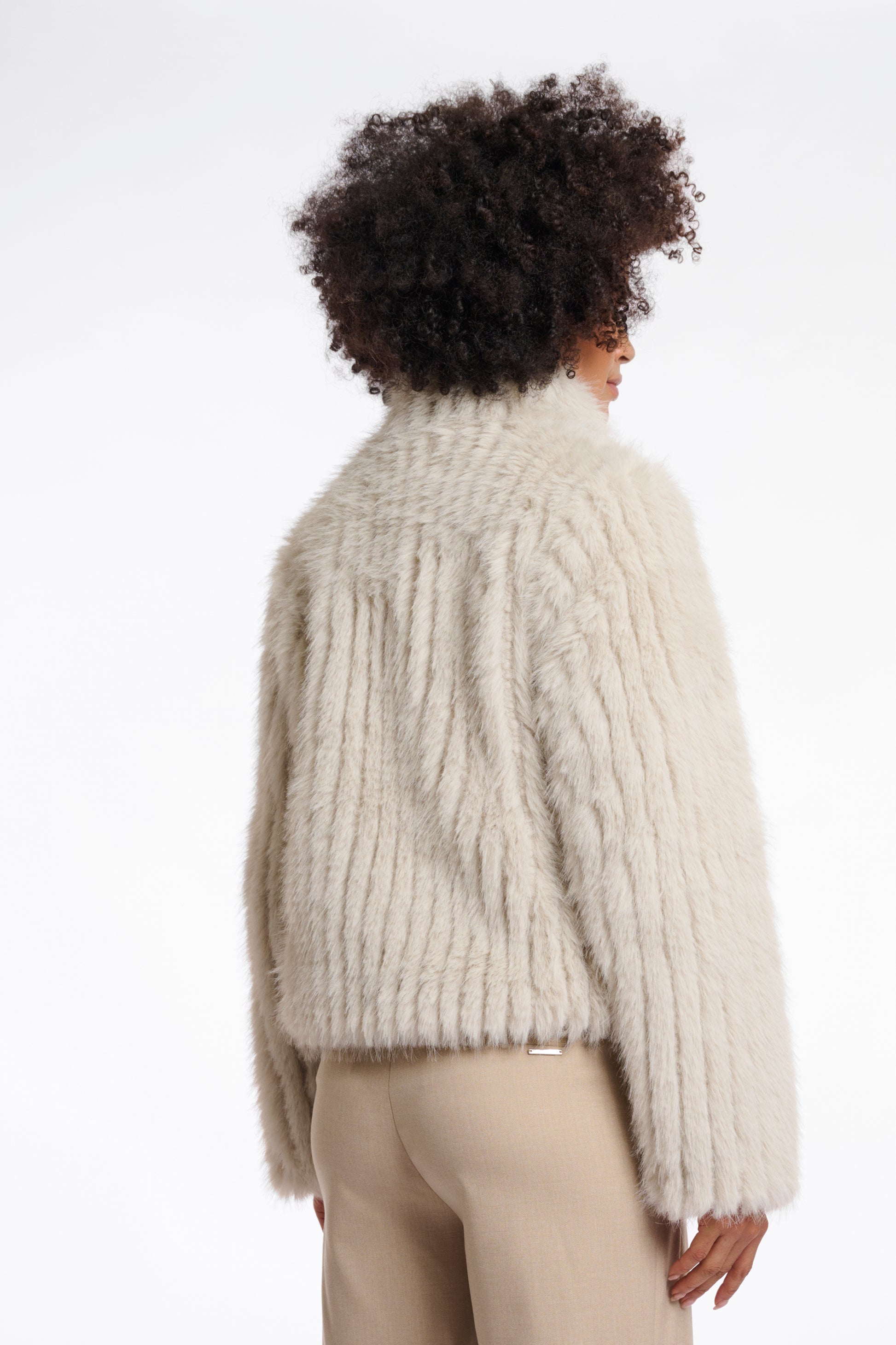beige faux fur jacket with high neck, central closure and stripe detailing in the fur rear view 