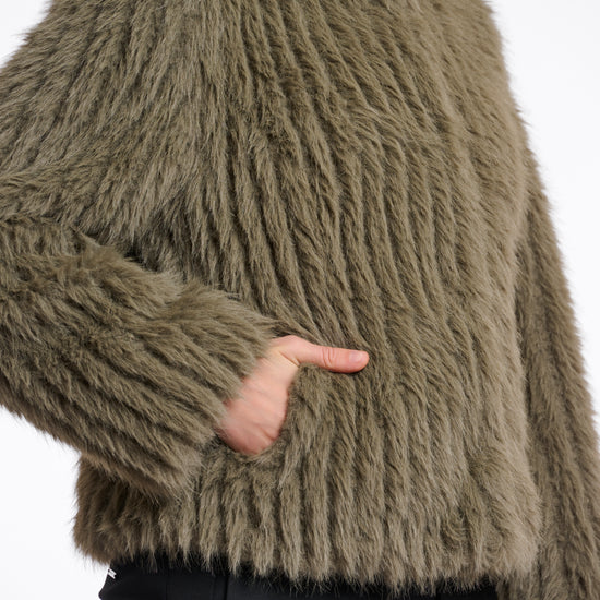 green faux fur jacket with central closure, high neck and stripe detailing in the fur side view 