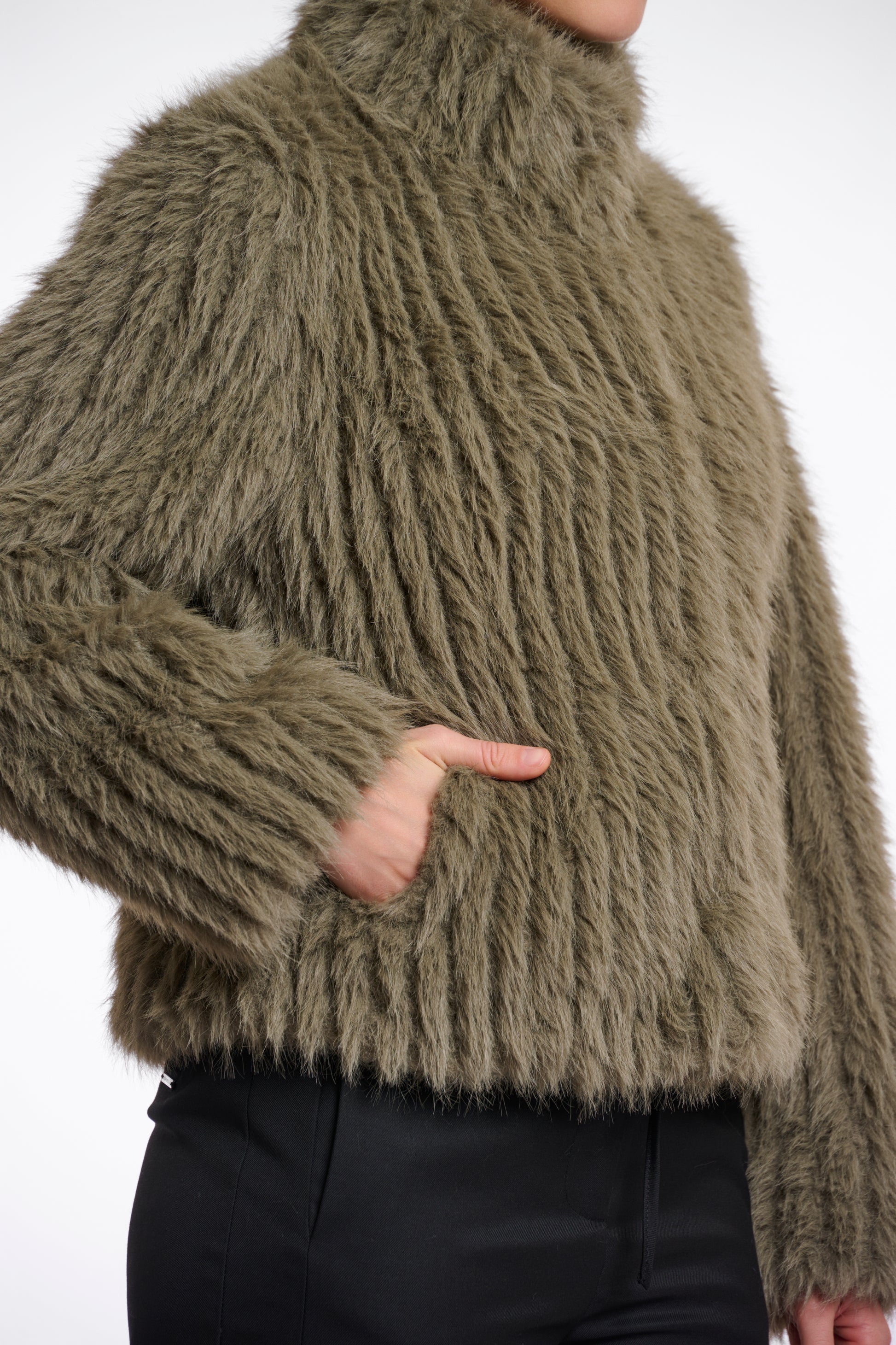 green faux fur jacket with central closure, high neck and stripe detailing in the fur side view 