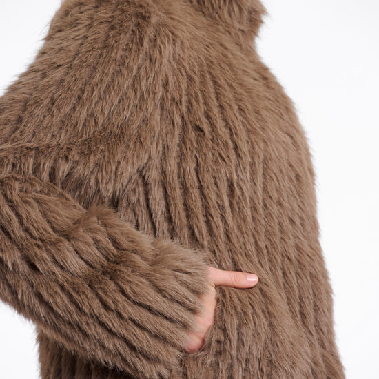 brown faux fur jacket with high neck, central closure and stripe detailing in the fur side view 