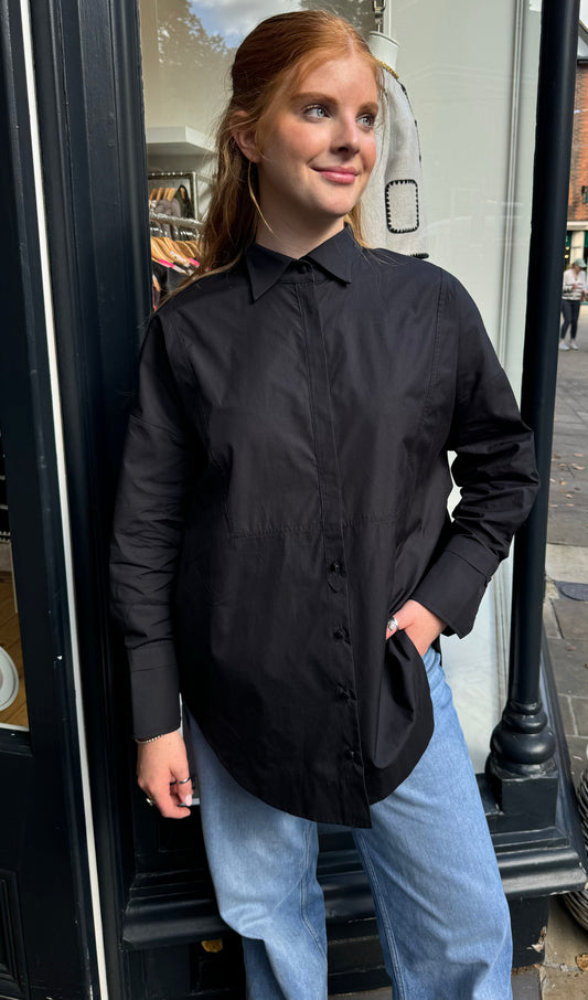 oversized black shirt with half covered placket and half exposed buttons 