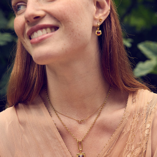 gold pendant heart necklace with red stone from rounded rectangular charm and gold chain from rachel jackson model shot