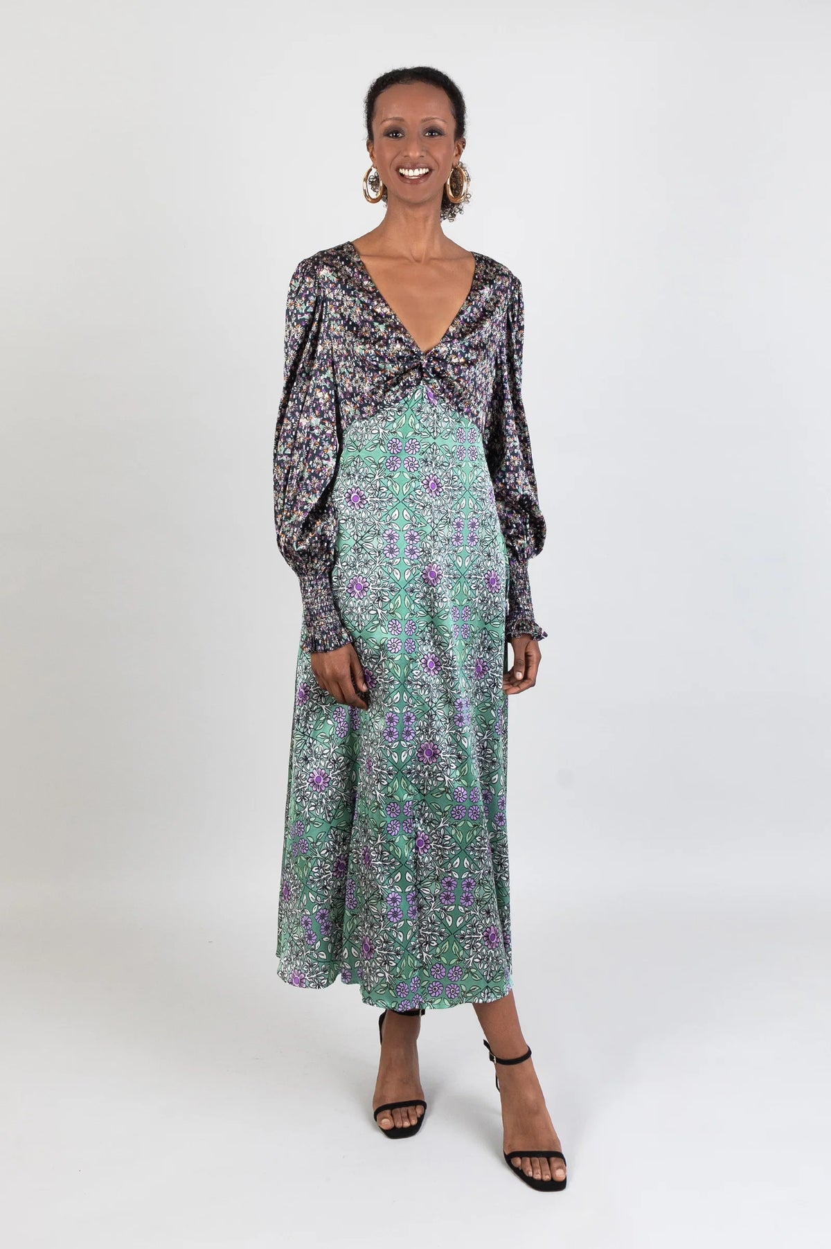 Twisted front V neck midi dress in two contrasting silk fabrics with long sleeves and shirred cuffs in a deep green and black tile print