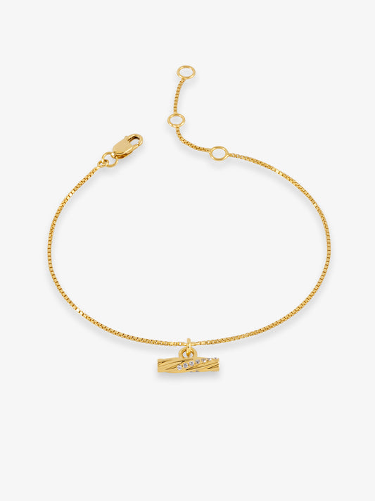 A delicate gold chain bracelet with a small horizontal bar charm displayed on a clean white background.