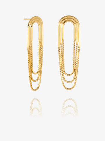 A pair of gold paperclip-shaped drop earrings with layered chain details, displayed on a clean white background with a soft reflection below.