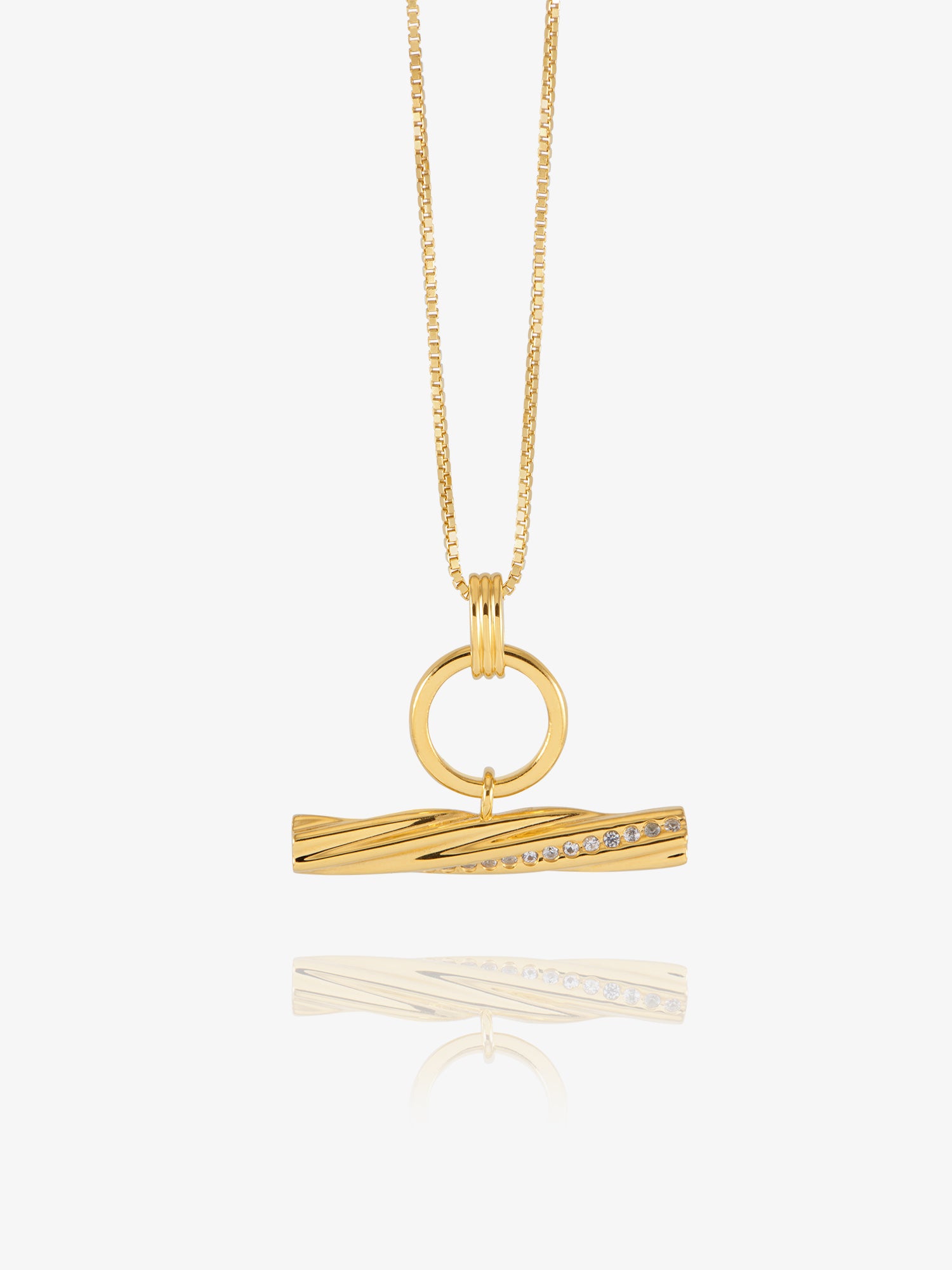 A gold pendant necklace featuring a twisted bar design with a row of small clear stones, suspended from a delicate gold chain against a light gray background.