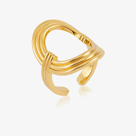 A polished gold-toned open ring ring with a multi-strand twisted design, shown on a light gray background with a soft reflection.