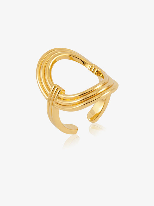 A polished gold-toned open ring ring with a multi-strand twisted design, shown on a light gray background with a soft reflection.