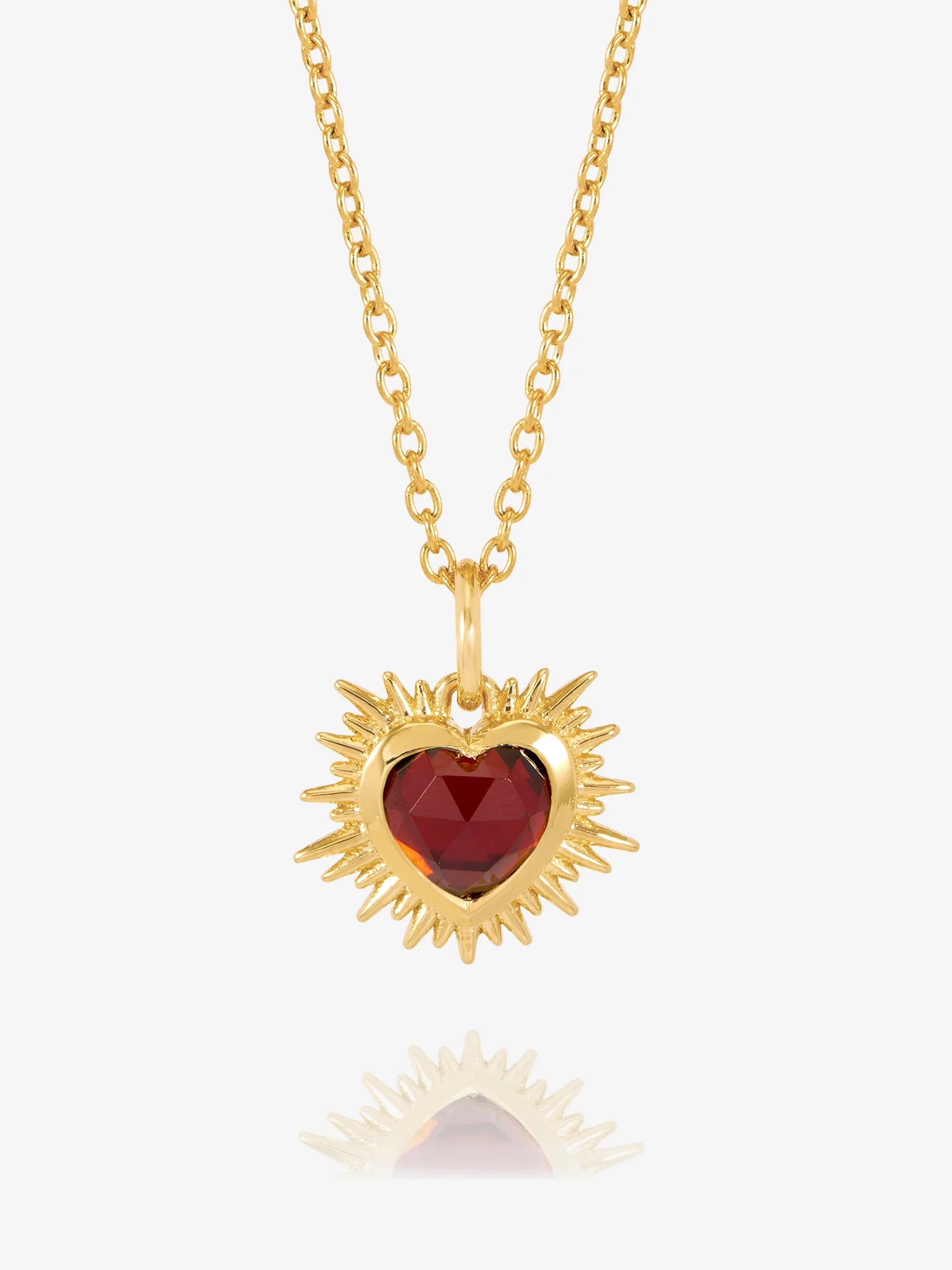gold spiky heart with red stone inside on a gold chain from rachel jackson