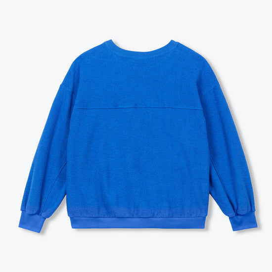 A bright blue long-sleeve crewneck sweatshirt shown from the back, laid flat against a light gray background.