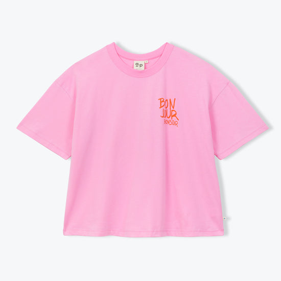 A light pink short-sleeve crop top t-shirt with a small orange graphic on the left chest, displayed flat against a light gray background.