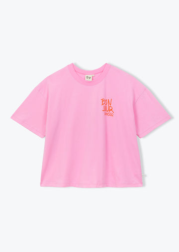 A light pink short-sleeve crop top t-shirt with a small orange graphic on the left chest, displayed flat against a light gray background.