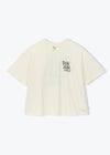 A cream-colored short-sleeve t-shirt with a black graphic text print on the left chest, displayed against a clean white background.