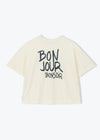 An off-white short-sleeve t-shirt with 'BON JOUR BONSOIR' printed in black across the back, displayed on a clean white background.