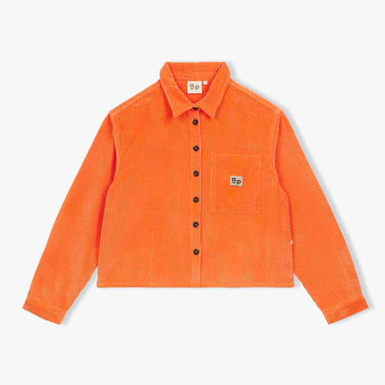 An orange corduroy button-up shirt jacket with a chest pocket and a small embroidered logo patch, displayed flat against a light gray background.