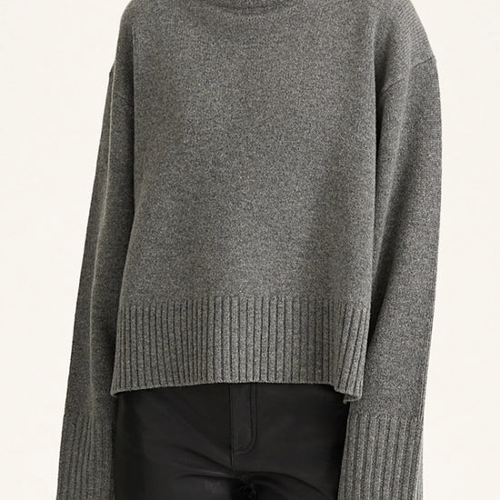 Gray turtleneck sweater worn by a person on a white background