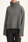 Gray turtleneck sweater worn by a person on a white background