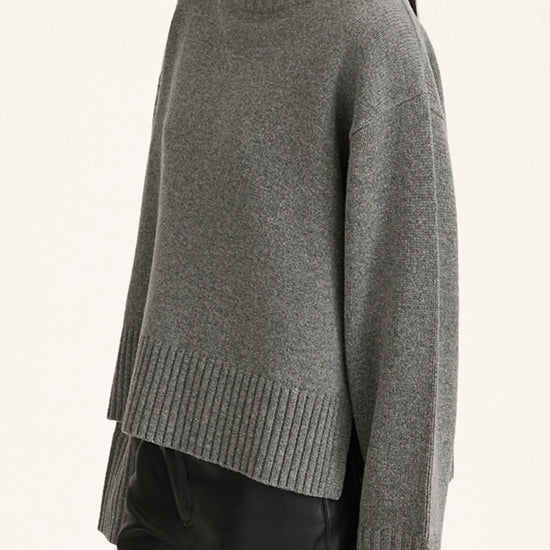 Gray turtleneck sweater worn by a person on a light gray background