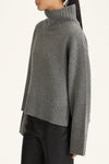 Gray turtleneck sweater worn by a person on a light gray background