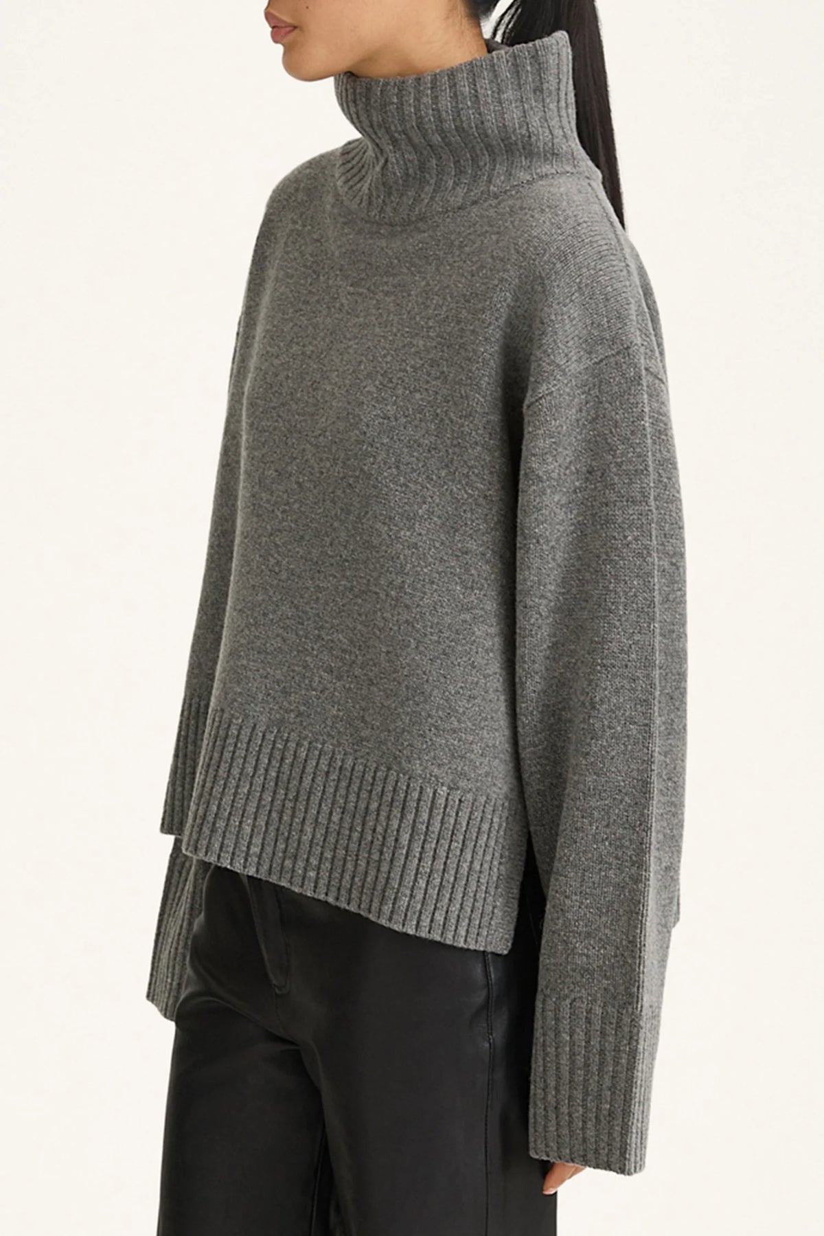 Gray turtleneck sweater worn by a person on a light gray background