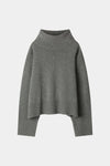 A dark gray knit turtleneck sweater with a relaxed, oversized fit, ribbed collar, cuffs, and hem, displayed against a light gray background.