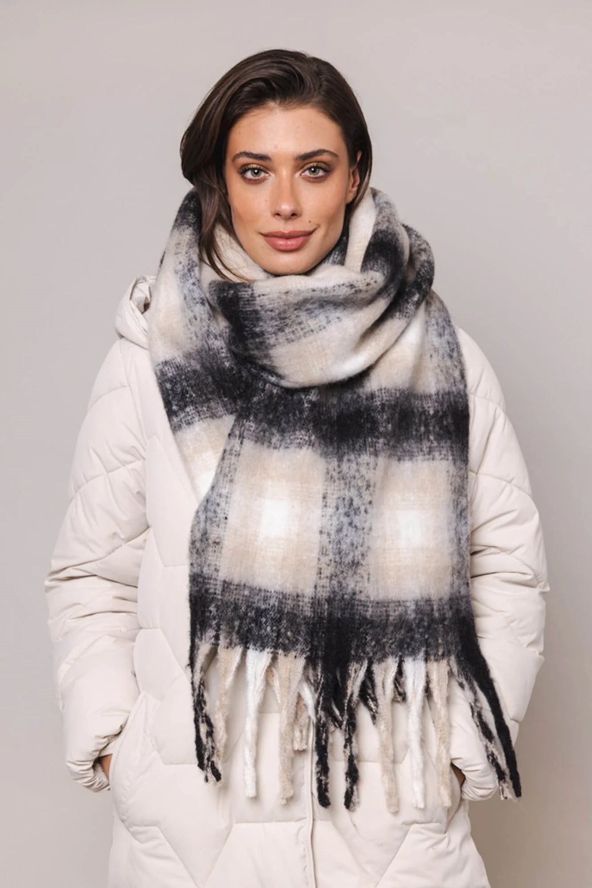 Light beige and black coloured check furry oblong scarf with tassels