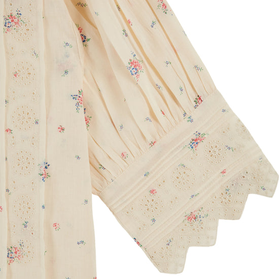 frill stand neck short sleeve pleated button down cream blouse with small floral print throughout from emile and ida close up