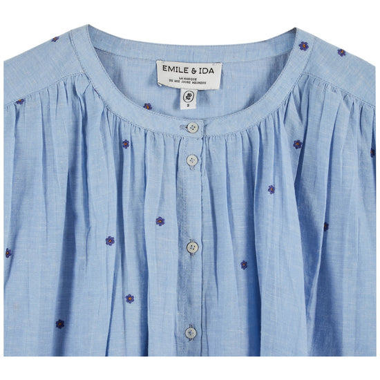 round neck button down blue blouse with short puffy sleeves and small dark blue dots throughout from emile and ida close up