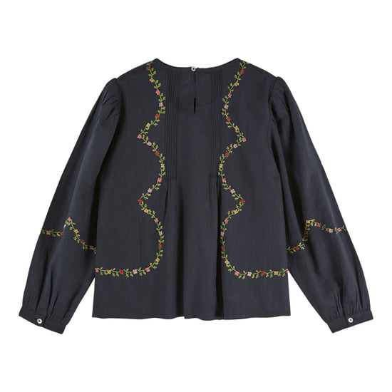 A dark charcoal gray long-sleeve blouse with wavy, scalloped floral embroidery in green, yellow, and red along the neckline and sleeves, shown against a plain white background.