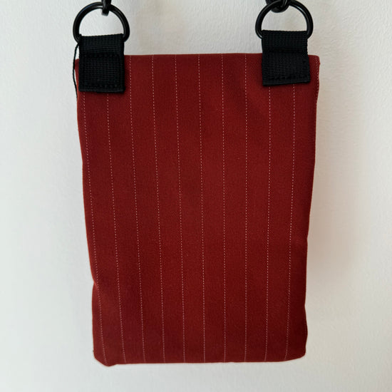 red pinstripe waterproof messenger bag with cross body strap rear view