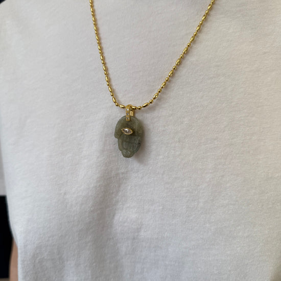 green hand pendant necklace on model 