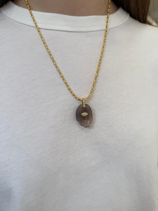 Grey hand pendant ono gold chain on model 