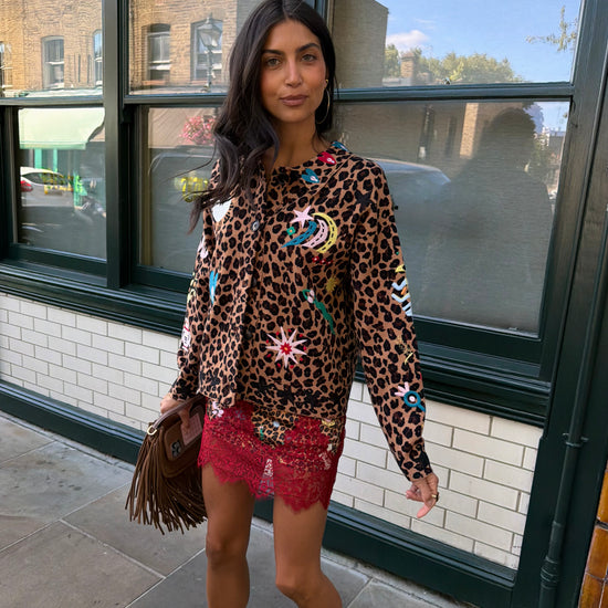 Woman wearing leopard print skirt and skirt with brightly coloured patches on them