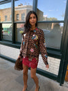 Woman wearing leopard print skirt and skirt with brightly coloured patches on them