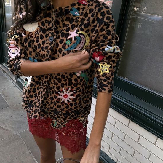 Woman wearing leopard print skirt and skirt with brightly coloured patches on them