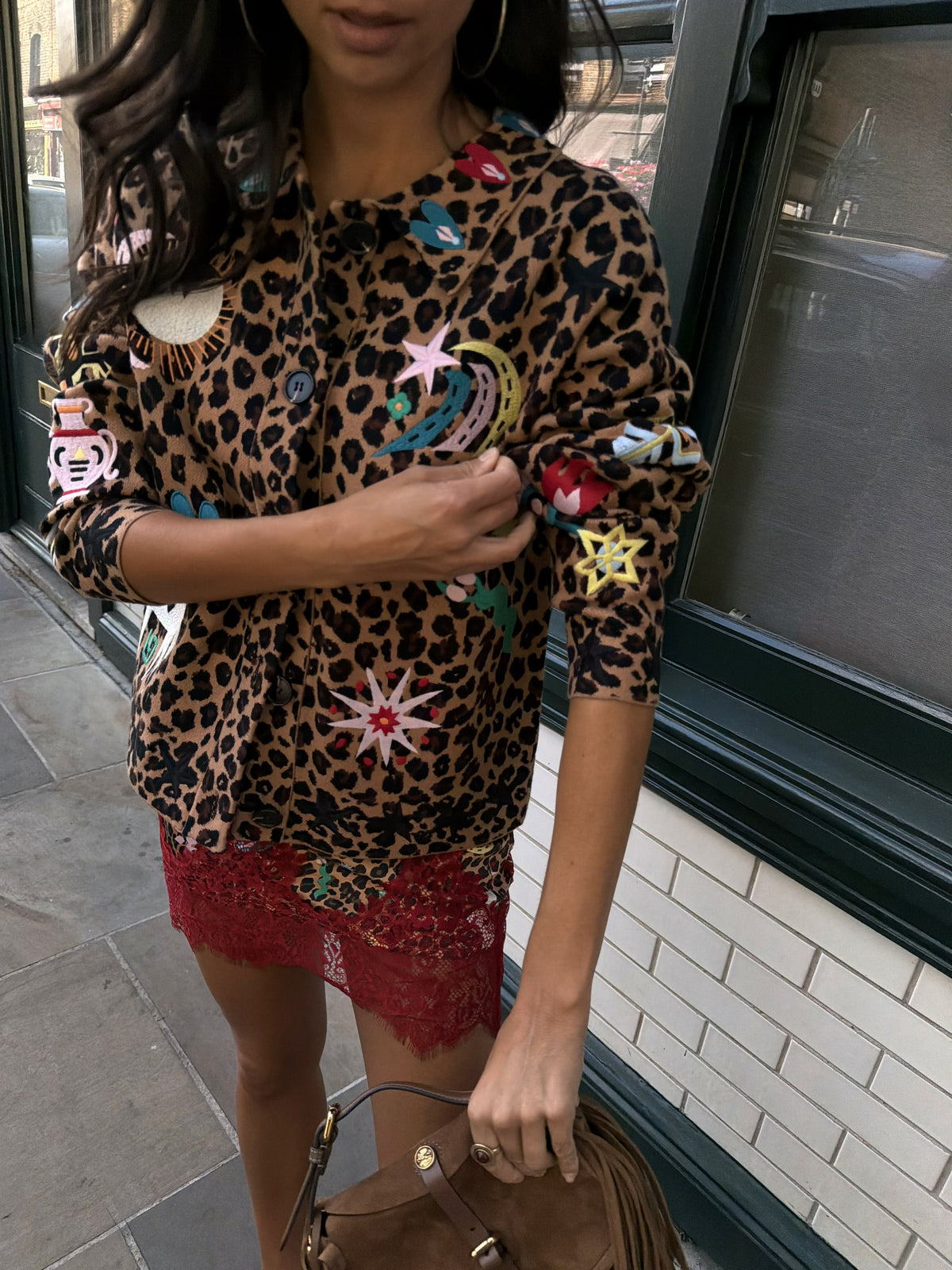 Woman wearing leopard print skirt and skirt with brightly coloured patches on them