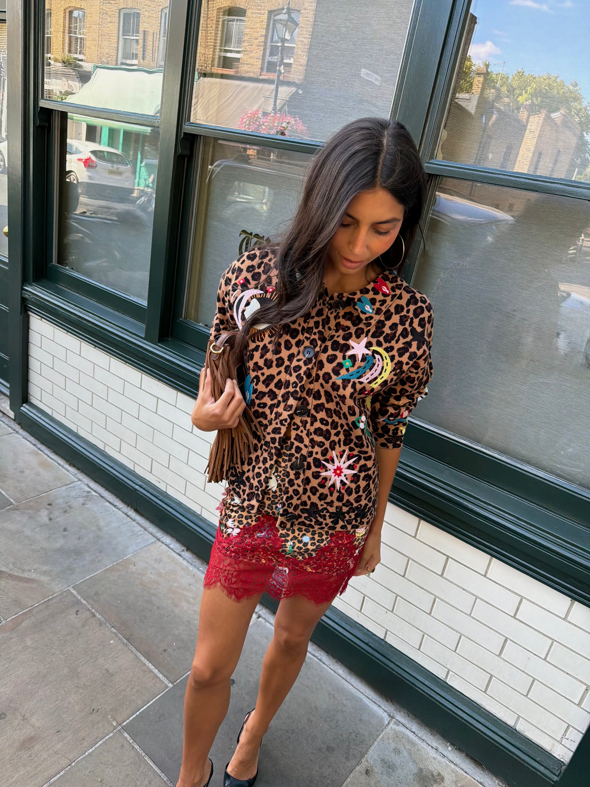Woman wearing leopard print skirt and skirt with brightly coloured patches on them