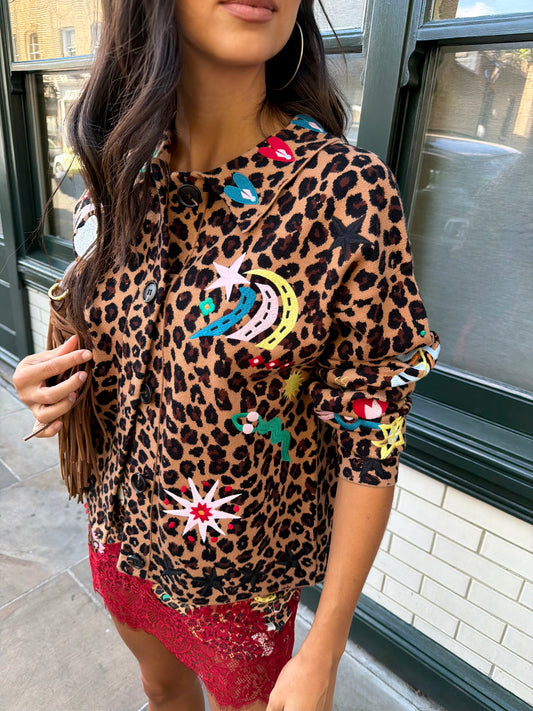 Woman wearing leopard print skirt and skirt with brightly coloured patches on them