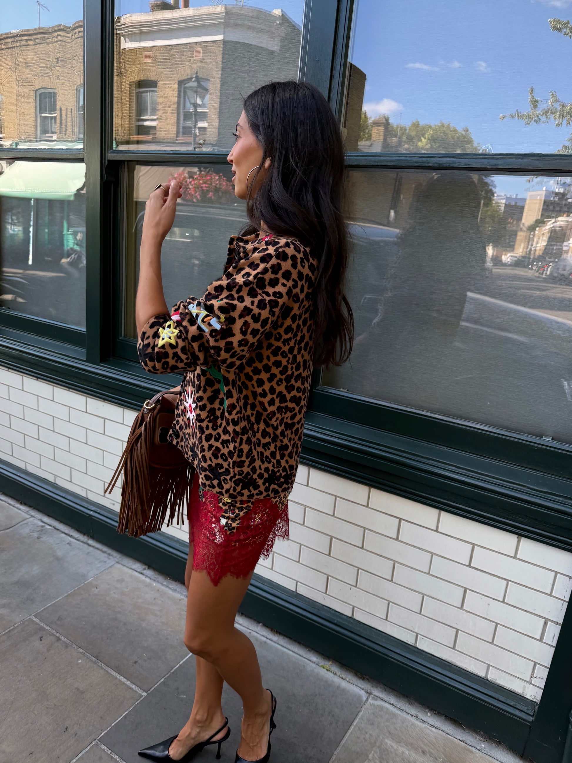 Woman wearing leopard print skirt and skirt with brightly coloured patches on them