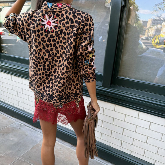 Woman wearing leopard print skirt and skirt with brightly coloured patches on them