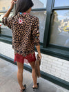 Woman wearing leopard print skirt and skirt with brightly coloured patches on them