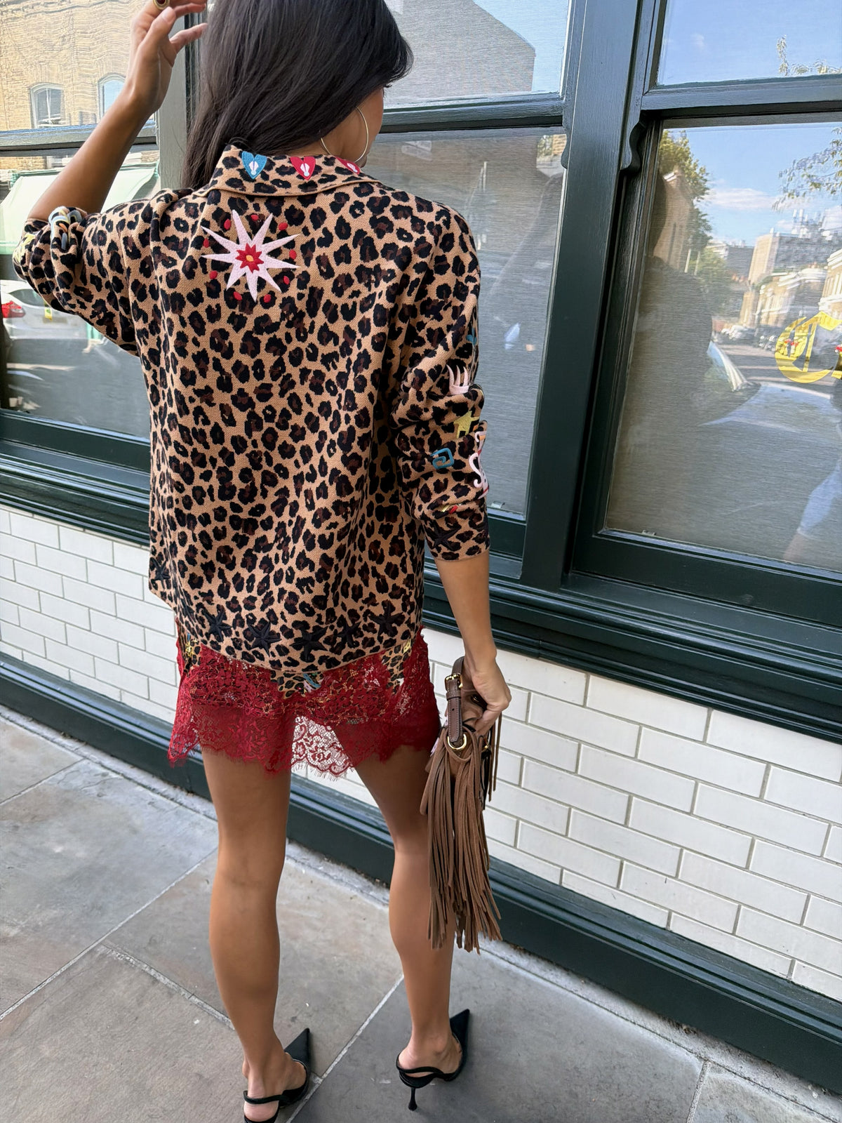 Woman wearing leopard print skirt and skirt with brightly coloured patches on them