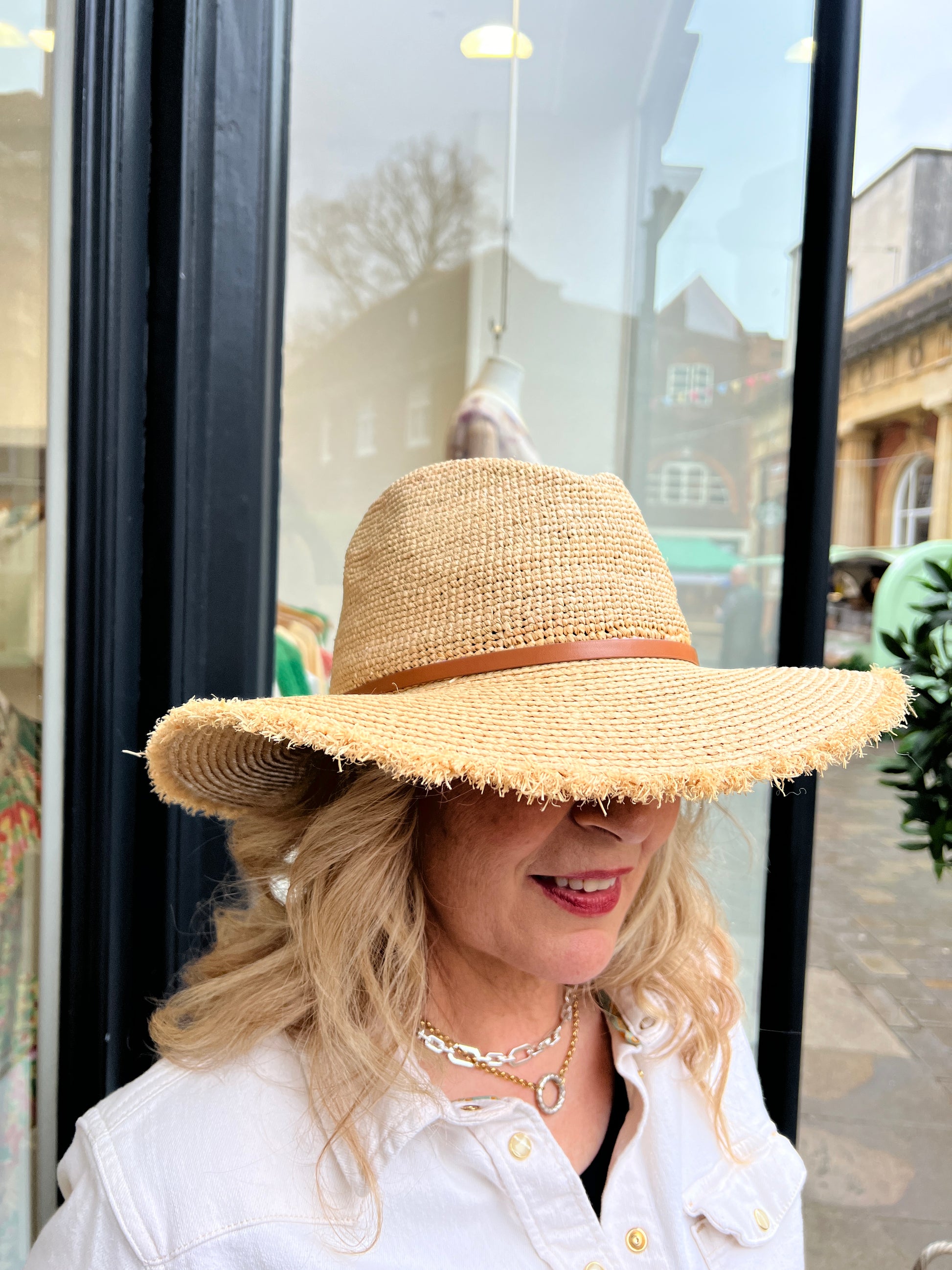 Adjustable sized Raffia hat with a broad rim and leather look detail