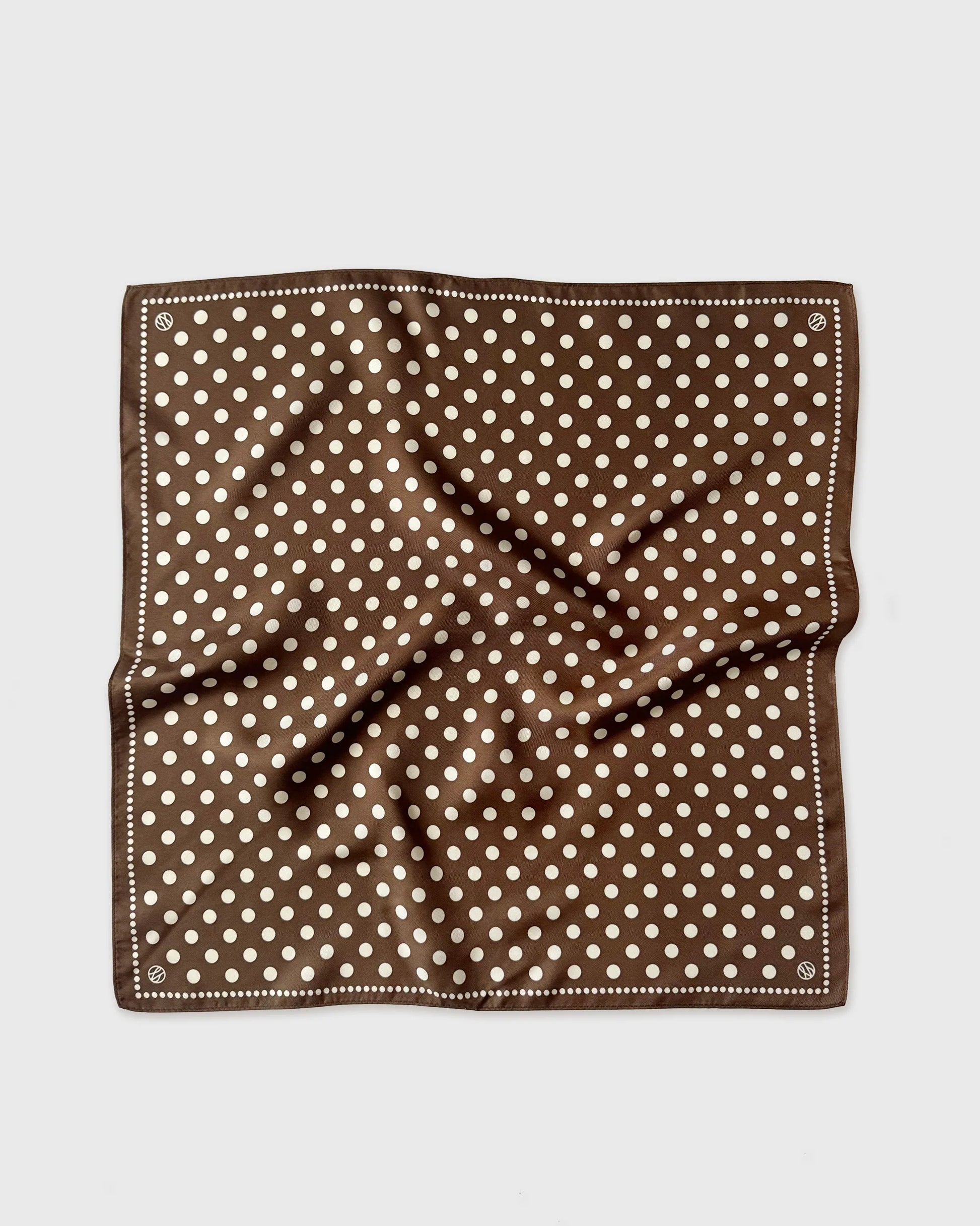 Brown pocket square with white polka dots on a light gray background